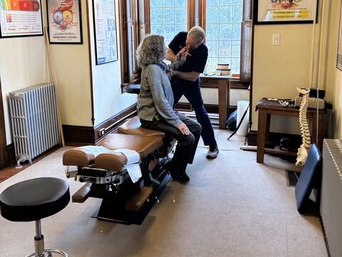 Dr. Schaffer adjusting a seated patient